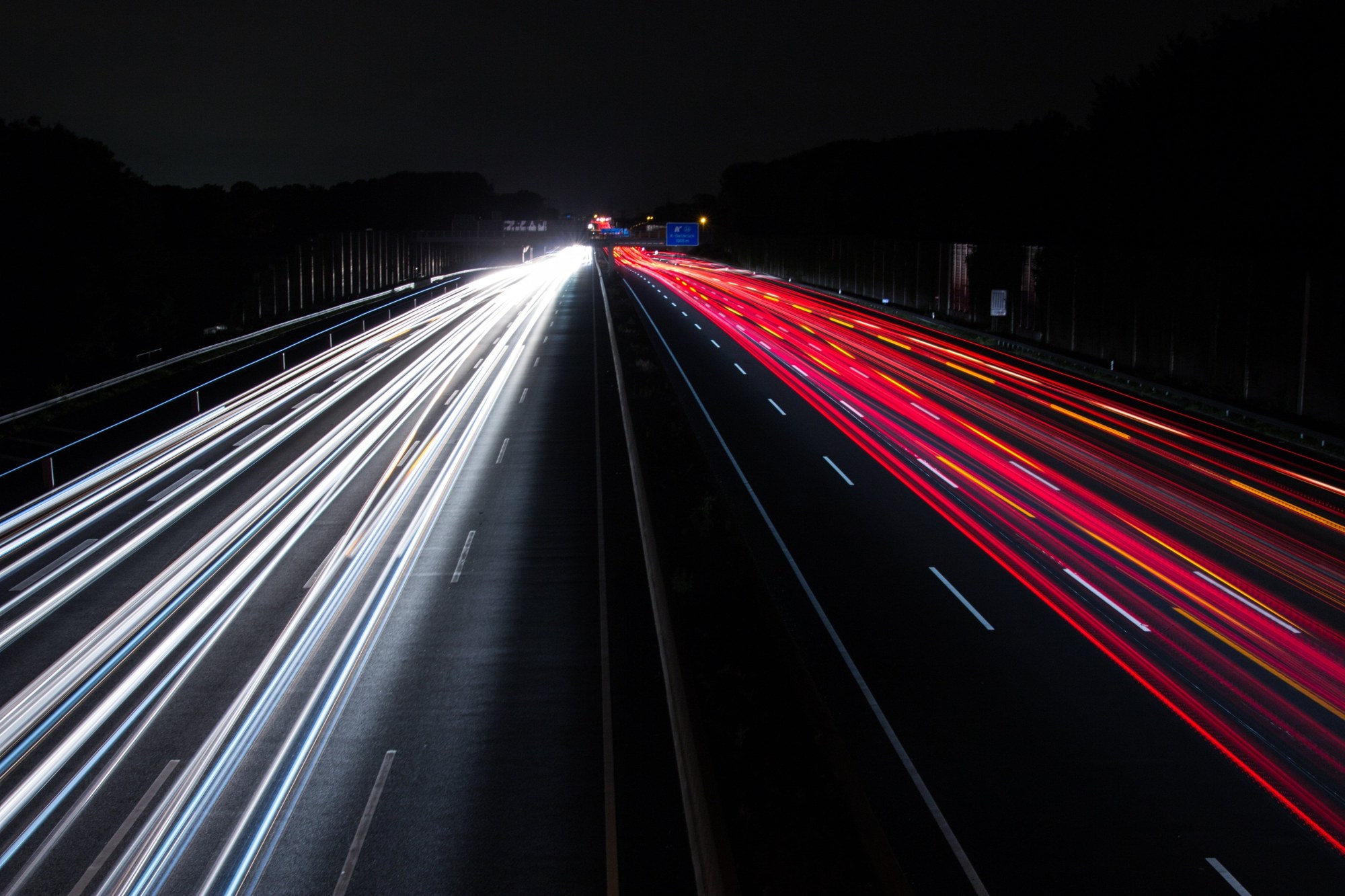 Night highway with long-exposure light trails from freight traffic